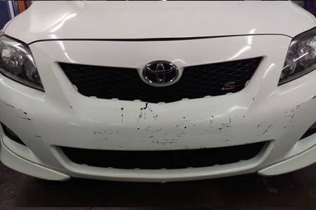Collision repair technician inspecting vehicle damage in Philadelphia